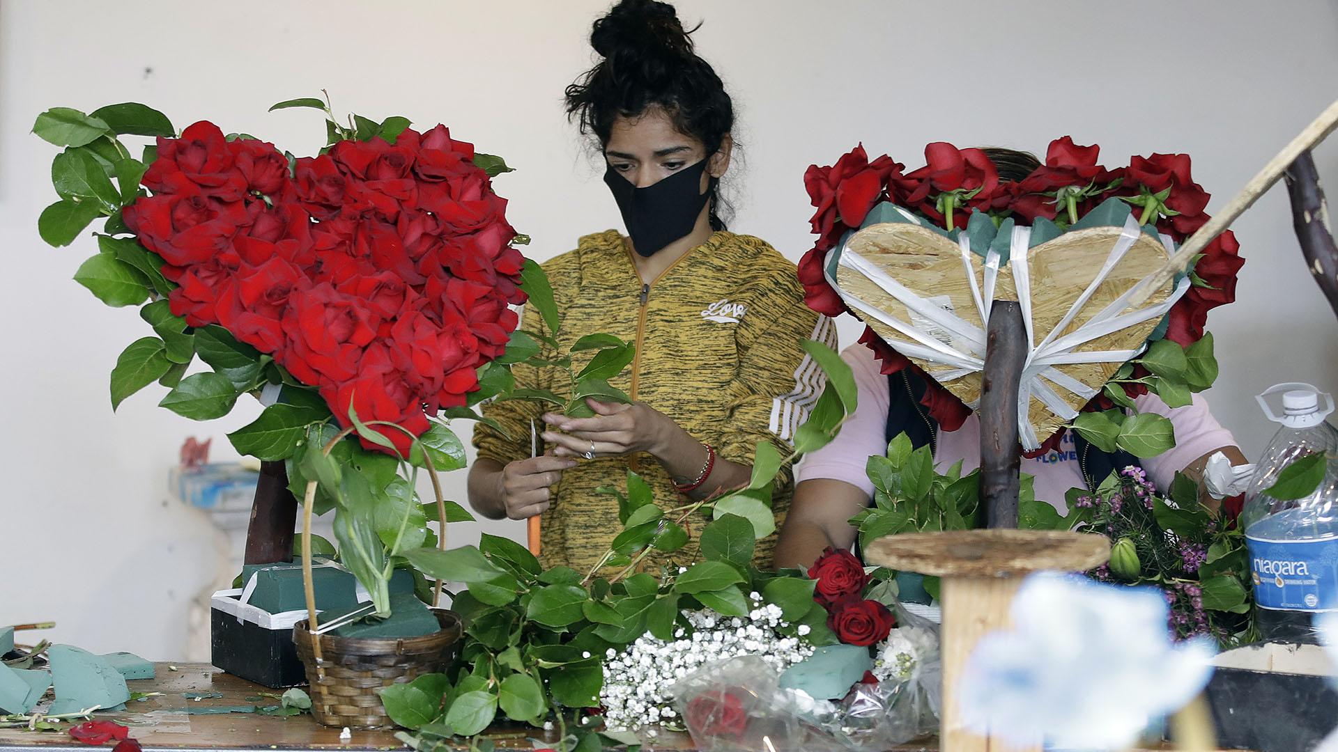 In this May 10, 2020, file photo, a merchant prepares a floral arrangement on Mother’s Day at the Los Angeles Flower Market in Los Angeles. (AP Photo / Marcio Jose Sanchez, File)