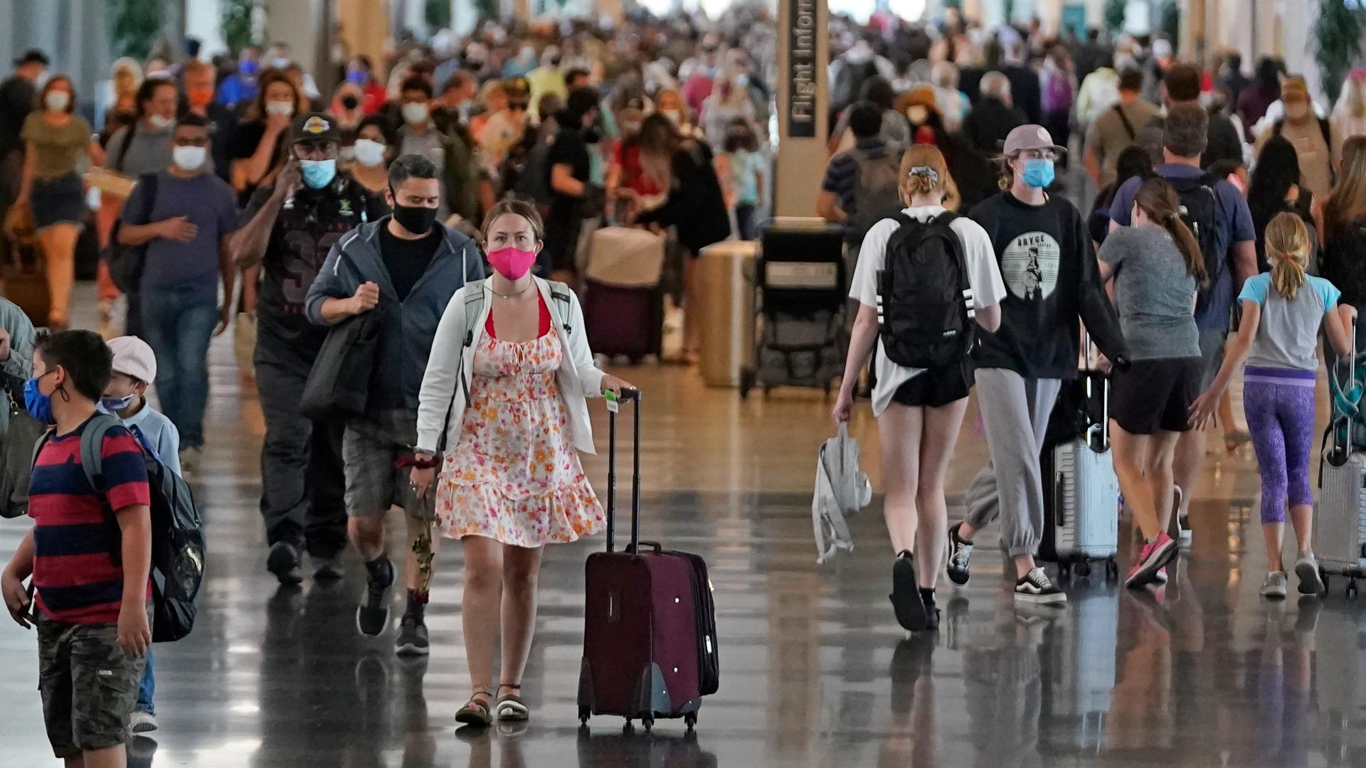 In this July 1, 2021, file photo, people walk through Salt Lake City International Airport in Salt Lake City. (AP Photo / Rick Bowmer, File)
