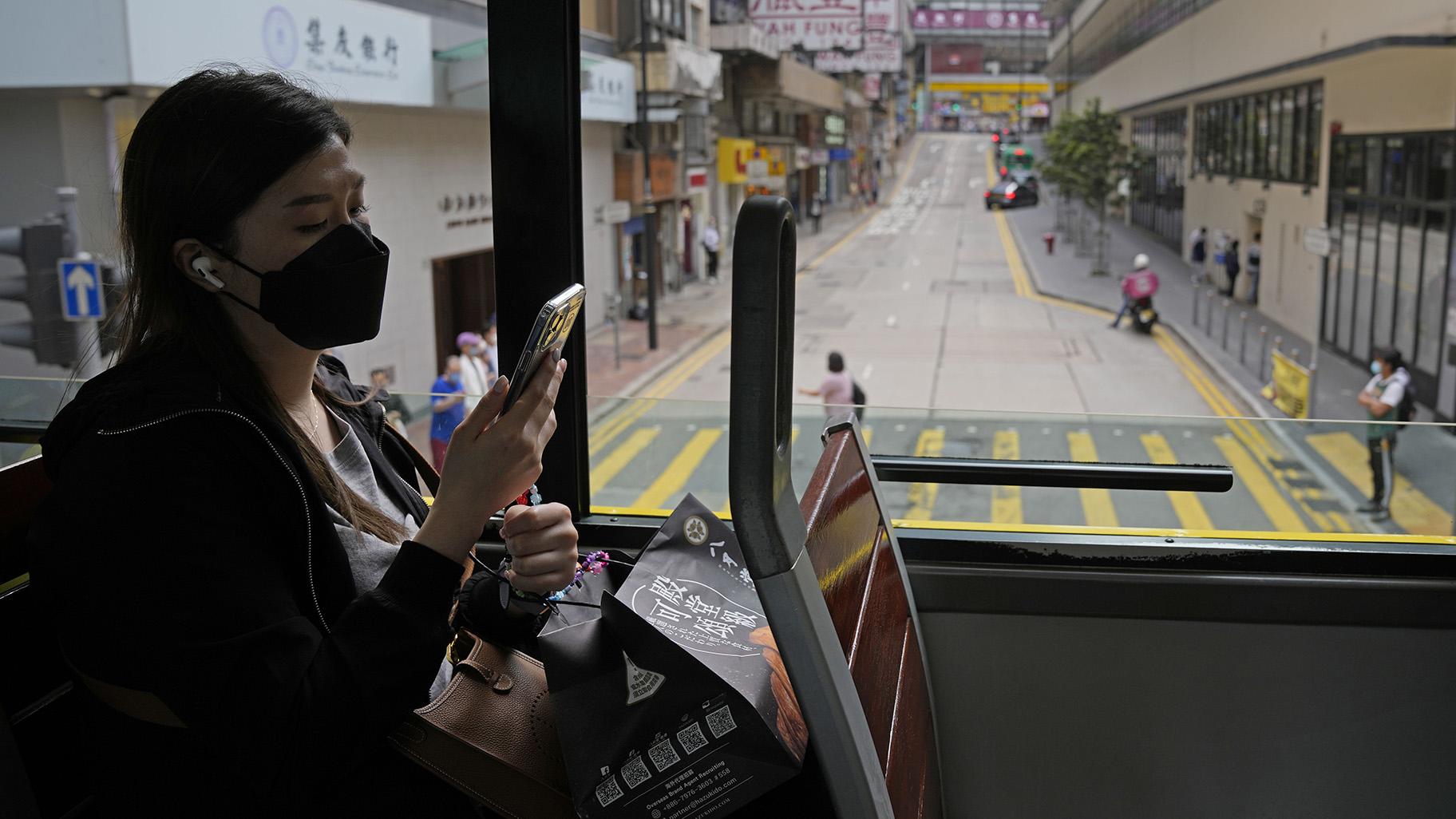 A woman wearing a face mask rides on a tram in Hong Kong, Wednesday, March 16, 2022. (AP Photo / Kin Cheung)