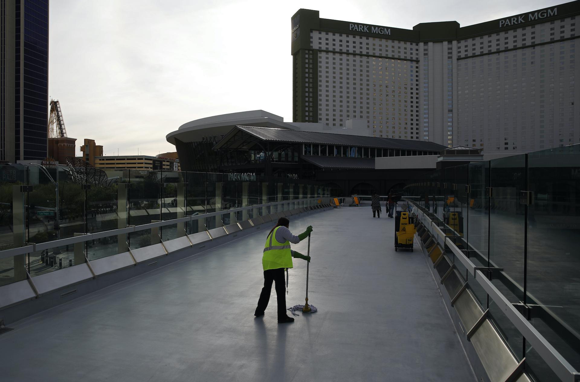 In this March 31, 2020, file photo, a worker cleans along the Las Vegas Strip devoid of the usual crowds as casinos and other business are shuttered due to the coronavirus outbreak in Las Vegas. (AP Photo/John Locher, File)