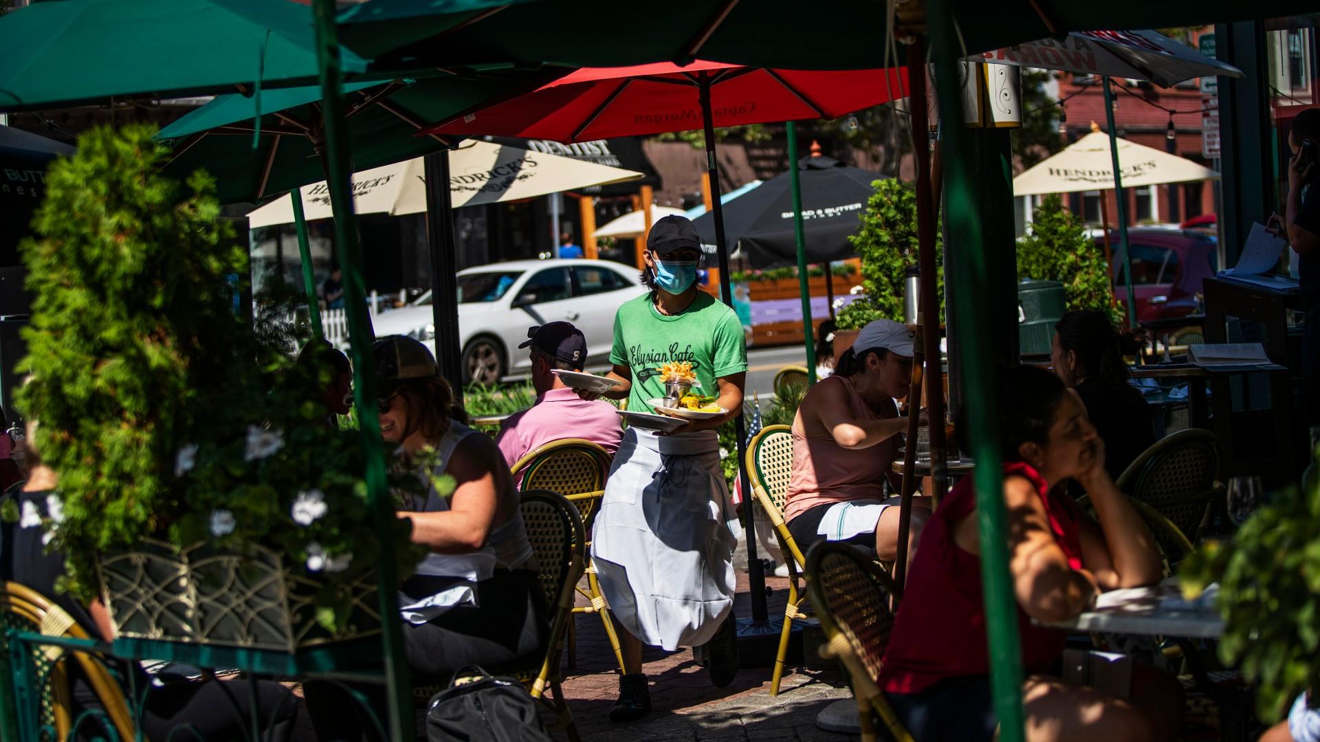 A waiter in a face mask delivers food to the tables outside of a local restaurant during lunch on Friday, Sept. 4, 2020, in Hoboken, N.J. (AP Photo / Eduardo Munoz Alvarez)