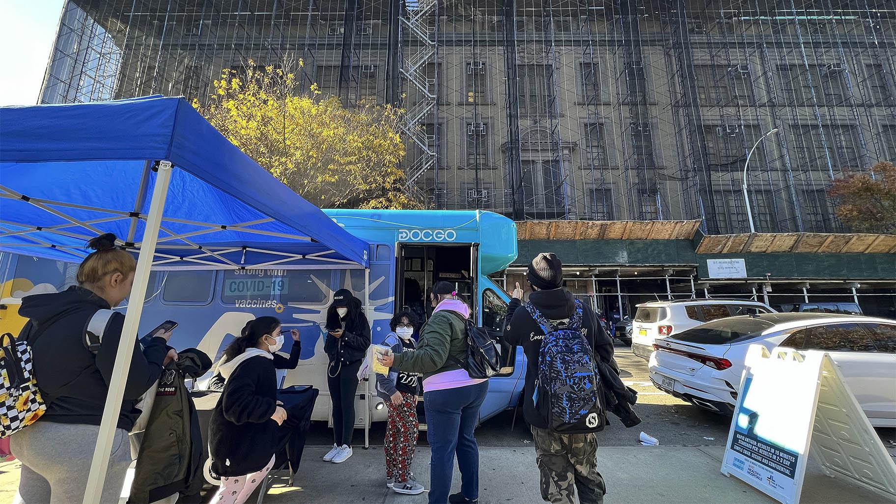 Children wait to go inside of a mobile vaccine unit to get their first COVID-19 vaccination shot, outside P.S. 277, Friday, Nov. 5, 2021, in the Bronx borough of New York. (AP Photo / Eduardo Munoz Alvarez)