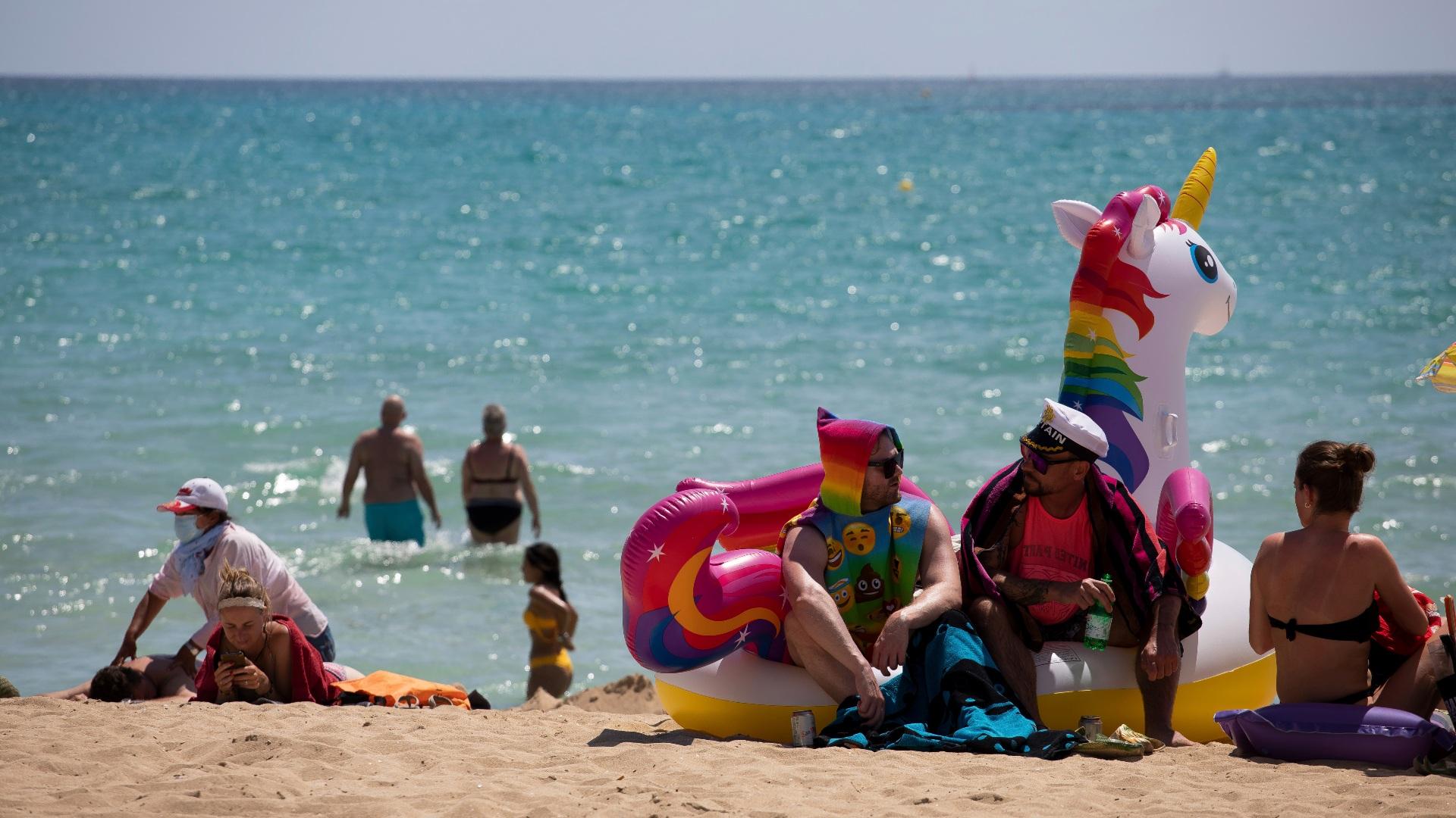 Tourists sunbathe on the beach at the Spanish Balearic Island of Mallorca, Spain, Monday, June 7, 2021. (AP Photo / Francisco Ubilla)