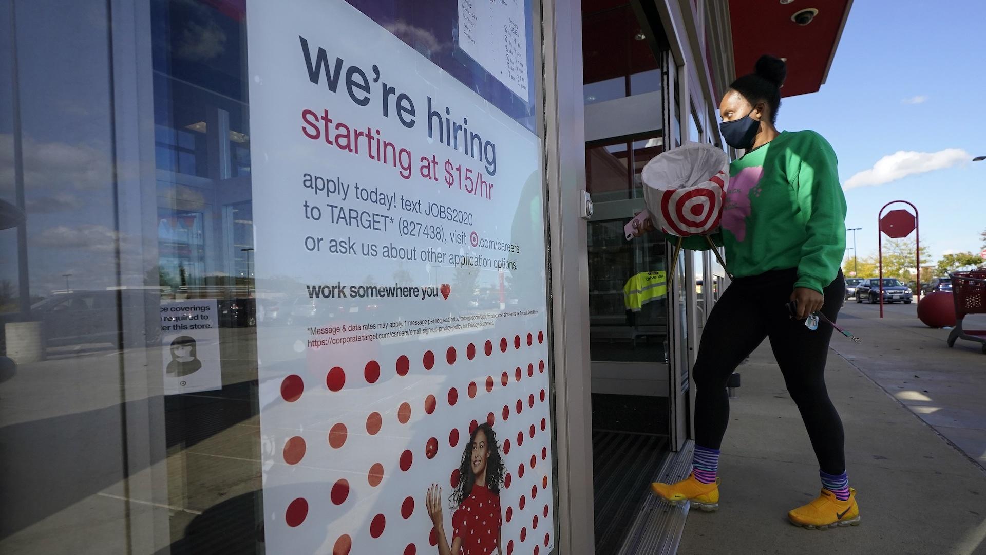 In this Sept. 30, 2020, file photo, a passerby walks past a hiring sign while entering a Target store in Westwood, Mass. (AP Photo/Steven Senne, File)