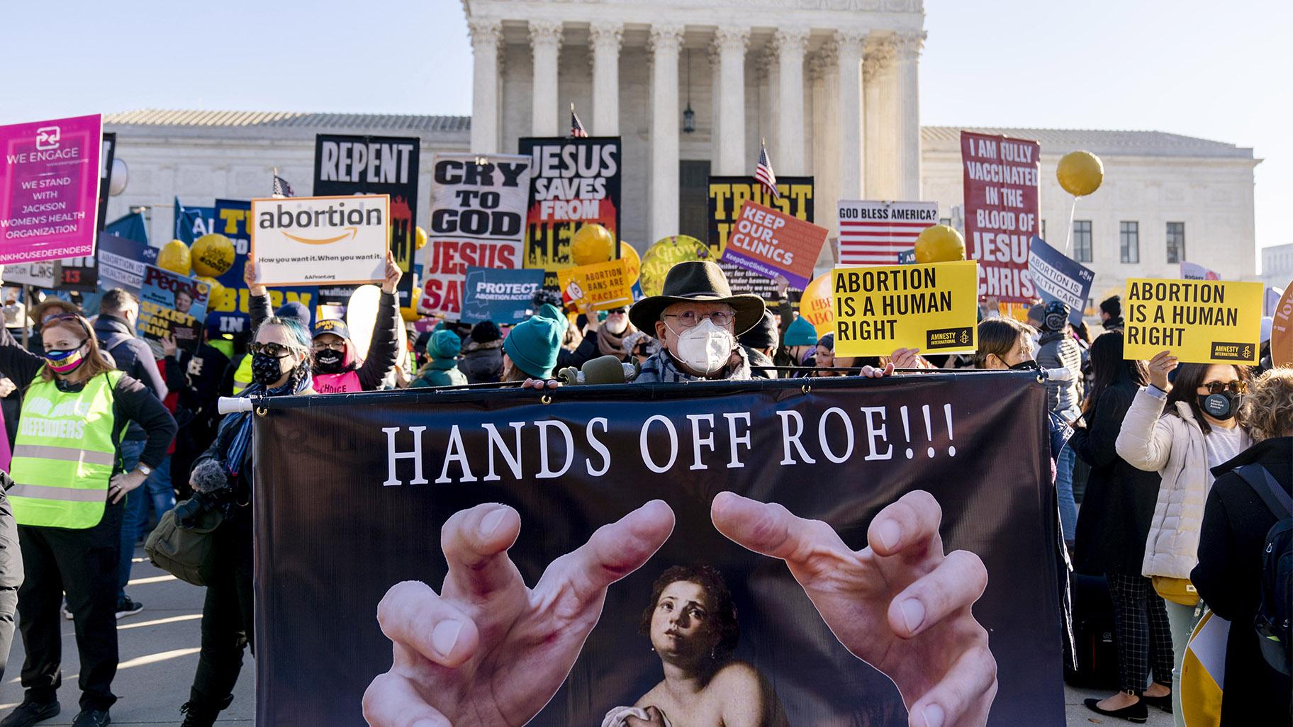 Stephen Parlato of Boulder, Colo., holds a sign that reads "Hands Off Roe!!!" as abortion rights advocates and anti-abortion protesters demonstrate in front of the U.S. Supreme Court, Dec. 1, 2021, in Washington, as the court hears arguments in a case from Mississippi, where a 2018 law would ban abortions after 15 weeks of pregnancy, well before viability. (AP Photo / Andrew Harnik, File) 