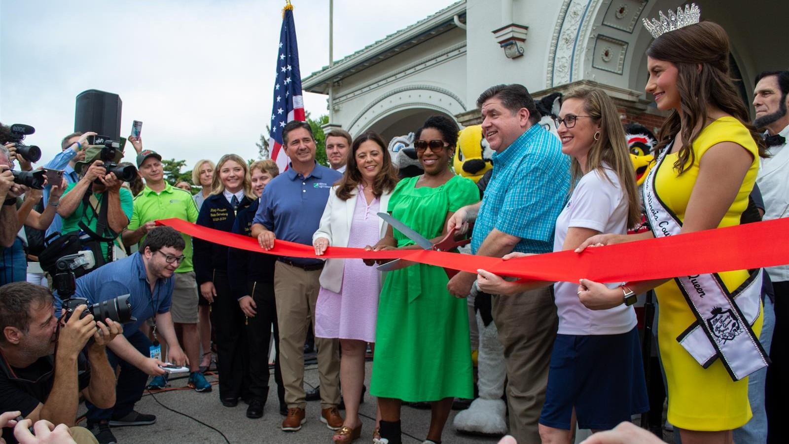 Gov. J.B. Pritzker, organizers of the Illinois State Fair and others cut the ribbon at the main gate of the Illinois State Fairgrounds last month. (Jerry Nowicki / Capitol News Illinois)