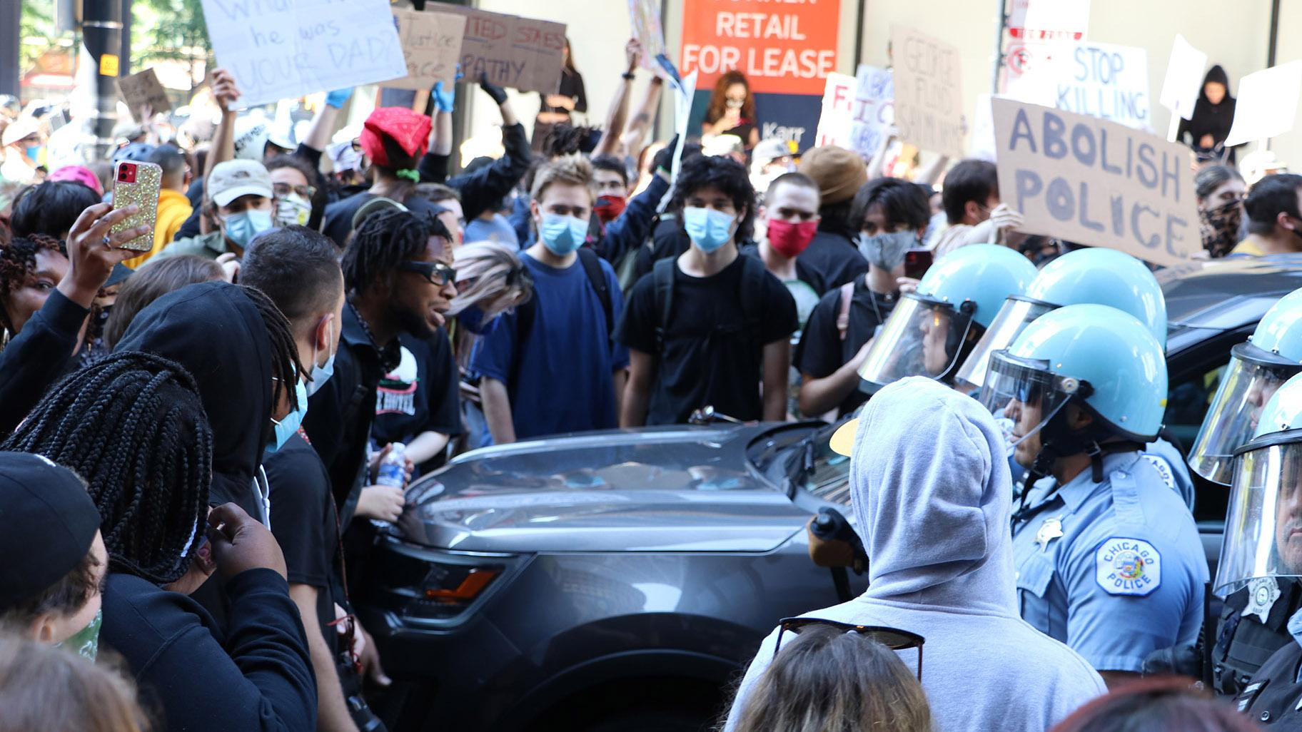 Protesters and police officers wearing riot gear have a standoff near Daley Plaza on Saturday, May 30, 2020. (Evan Garcia / WTTW News)