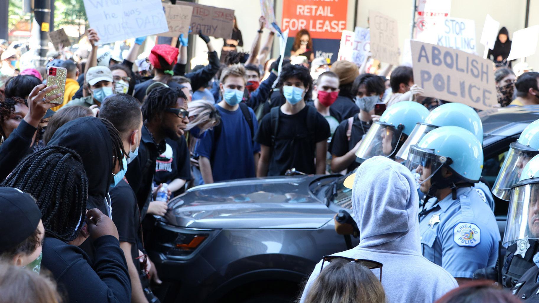 Protesters and police officers wearing riot gear have a standoff near Daley Plaza on Saturday, May 30, 2020. (Evan Garcia / WTTW News)