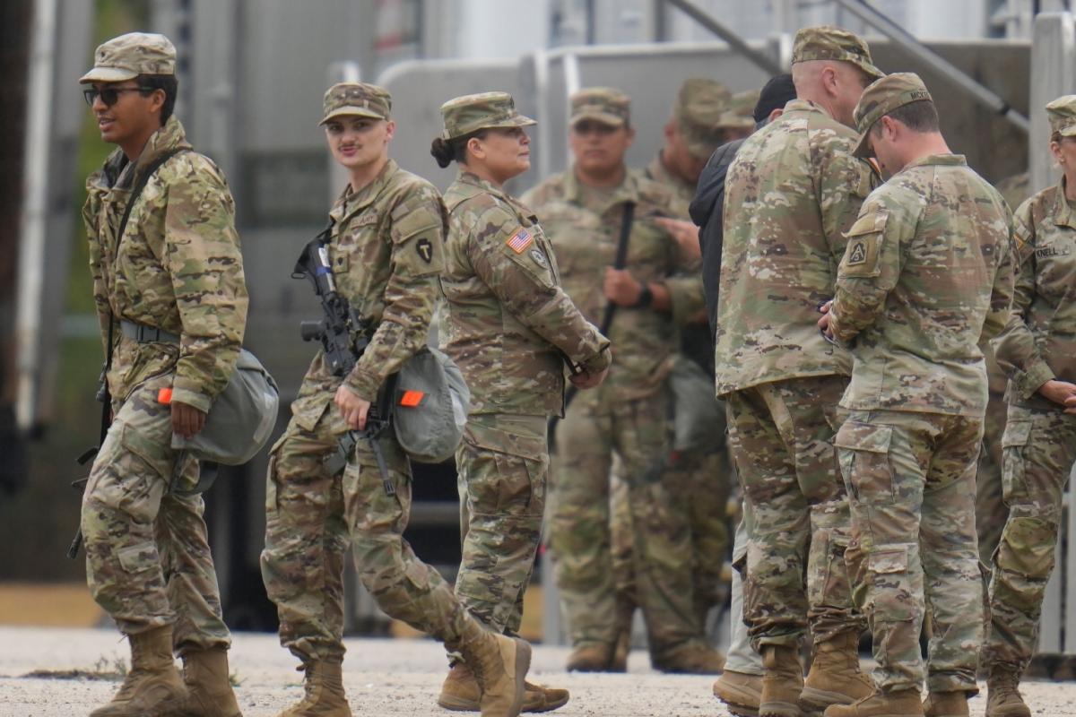 Military personnel in uniform, with the Texas National Guard patch on, are seen at the U.S. Army Reserve Center, Tuesday, Oct. 7, 2025, in Elwood, Ill., a suburb of Chicago. (AP Photo/Erin Hooley)