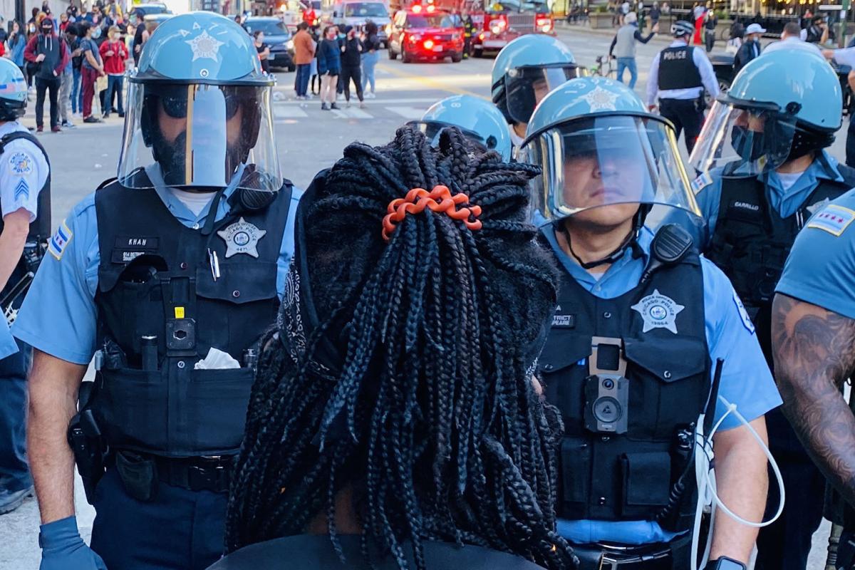 A protester faces a line of police officers in Chicago on Saturday, May 30, 2020. (Hugo Balta / WTTW News)
