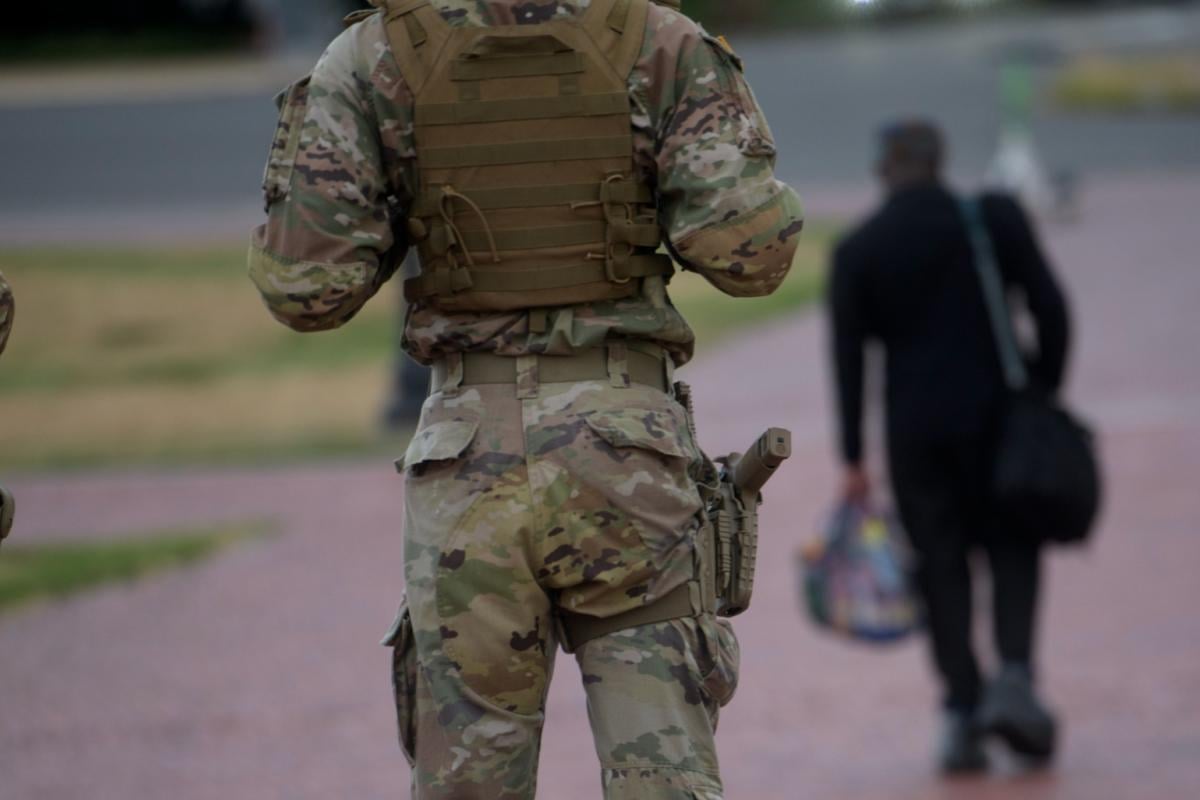 Armed members of the South Carolina National Guard talk with a man while positioned outside of Union Station in Washington, Sunday, Aug. 24, 2025. (AP Photo / Rod Lamkey, Jr.)