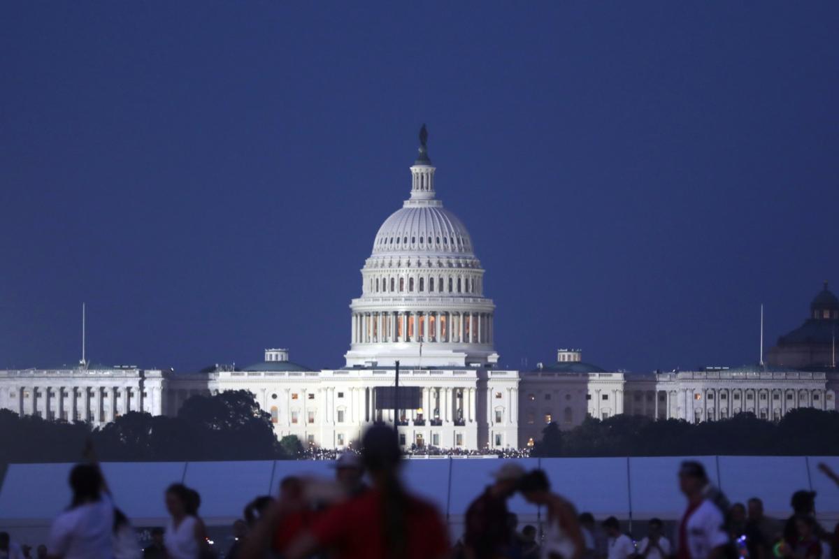 The U.S. Capitol building stands as people wait to watch fireworks near the Washington Monument during Fourth of July celebrations, in Washington, Friday, July 4, 2025. (AP Photo / Rahmat Gul)