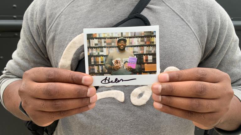 Harold Moore, 40, of Austin poses with a polaroid of him inside the Criterion Mobile Closet on Oct. 17, 2025. He picked out Mira Nair’s “Mississippi Masala” (1991), a Robert Downey Sr. film collection and a Melvin Van Peebles film collection. (Eunice Alpasan / WTTW News)