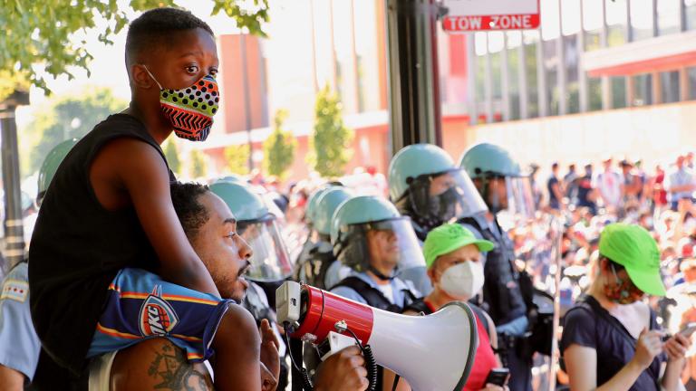 Jahan James, 8, sits on the shoulders of his father, Jonathan James, who addresses the crowd during a protest on Tuesday, June 2, 2020 in Old Town. (Evan Garcia / WTTW News)