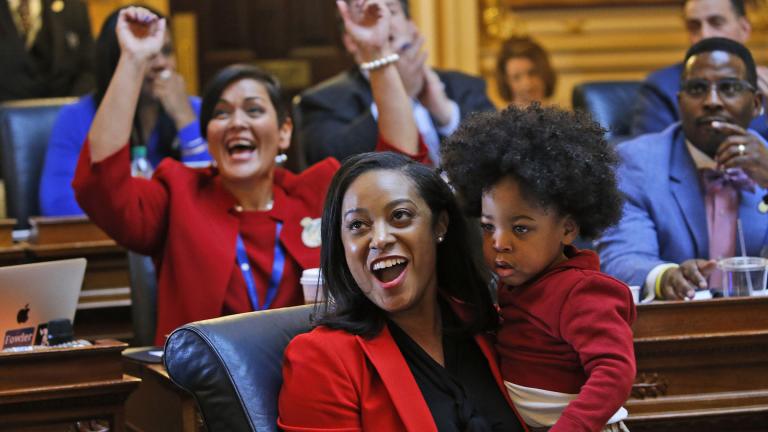 In this Jan 27, 2020, file photo, Virginia Delegate Jennifer Carroll Foy holds her son, Alex Foy, as she and Delegate Hala Ayala, D-Prince William, back, celebrate the passage of the Equal Rights Amendment in the House chambers at the Capitol in Richmond, Va. (AP Photo / Steve Helber, File)