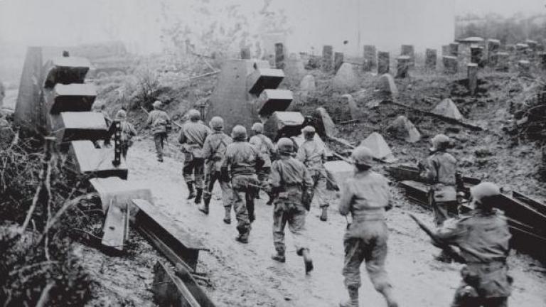 US Infantry advancing through a hole blasted in the Siegfried Line, or Westall, in October 1944. (Viking Penguin)