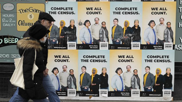 FILE - In this Wednesday, April 1, 2020 file photo, People walk past posters encouraging participation in the 2020 Census in Seattle's Capitol Hill neighborhood. (AP Photo / Ted S. Warren, File)