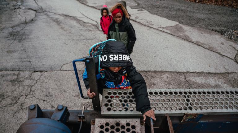 Jeremiah Johnson and his mother, Lamira Samson, climb over a parked freight train on their way to school. (Courtesy of ProPublica)