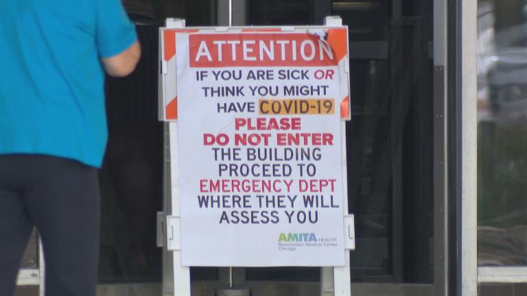A sign directs patients with COVID-19 symptoms to the emergency department at AMITA Health Resurrection Medical Center Chicago on Tuesday, May 26, 2020. (WTTW News)