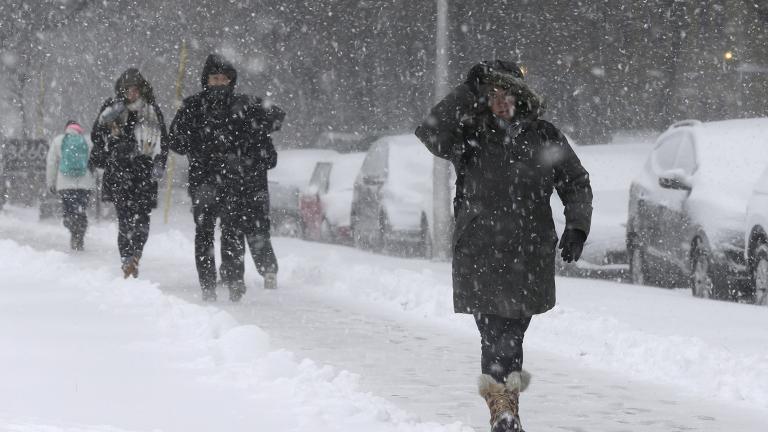 Commuters walk to a bus stop as snow falls, Monday, Nov. 26, 2018, in Chicago. (Kiichiro Sato / AP Photo)