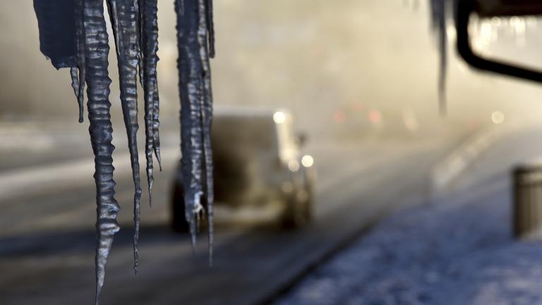 Icicles hang from the Harrington Inn in Geneva, Ill., as commuters pass by on Thursday, Jan. 31, 2019. (Jeff Knox / Daily Herald via AP)