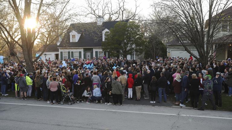 Mourners gather outside the home of 5-year-old Andrew "AJ" Freund for a vigil Wednesday, April 24, 2019, in Crystal Lake, Ill. Andrew's body was found in a wooded area in Woodstock Wednesday, and the boy's parents have been charged with his murder. (John J. Kim/Chicago Tribune via AP)