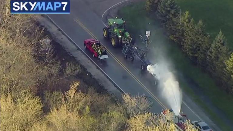 In this still image from video provided by ABC7 Chicago, a fire engine sprays water on a container of the chemical that farmers use for soil after anhydrous ammonia leaked Thursday, April 25, 2019, in Beach Park, Illinois. (ABC7 Chicago via AP)