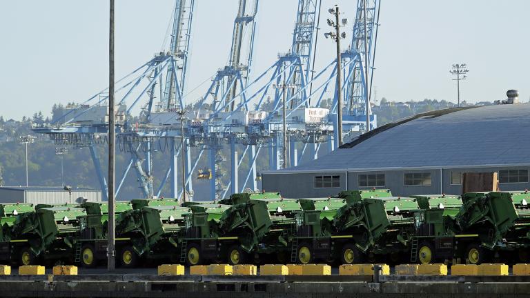 In this May 10, 2019, file photo John Deere Agricultural machinery made by Deere & Company sits staged for transport near cranes at the Port of Tacoma in Tacoma, Washington. (AP Photo / Ted S. Warren, File)
