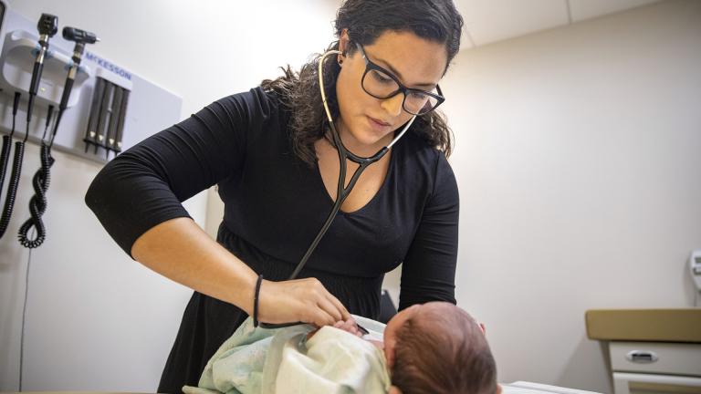 In this Tuesday, Aug. 13, 2019, photo, Dr. Jasmine Saavedra, a pediatrician at Esperanza Health Centers whose parents emigrated from Mexico in the 1980s, examines Alondra Marquez, a newborn baby in her clinic in Chicago. (AP Photo / Amr Alfiky)