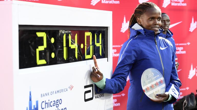 Brigid Kosgei of Kenya, poses with her time after winning the Women’s Bank of America Chicago Marathon while setting a world record of 2:14:04, Sunday, Oct. 13, 2019, in Chicago. (AP Photo / Paul Beaty)