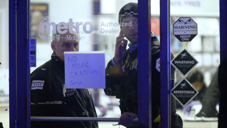 A police supervisor and officer stand inside a cell phone store in the 3700 block of West 26th Street, where a 7-year-old girl was shot while trick-or-treating Thursday, Oct. 31, 2019, in Chicago. (John J. Kim / Chicago Tribune via AP) A police supervisor and officer stand inside a cell phone store in the 3700 block of West 26th Street, where a 7-year-old girl was shot while trick-or-treating Thursday, Oct. 31, 2019, in Chicago. (John J. Kim / Chicago Tribune via AP)