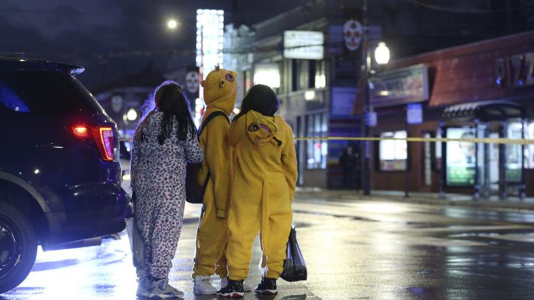 A group of children view a crime scene, where a 7-year-old girl was shot while trick-or-treating Thursday, Oct. 31, 2019, in Chicago. (John J. Kim / Chicago Tribune via AP)