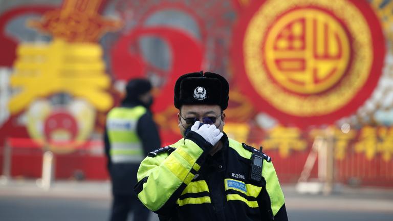 A traffic policeman adjusts his mask on a street in Beijing, Sunday, Feb. 9, 2020. (AP Photo / Andy Wong)