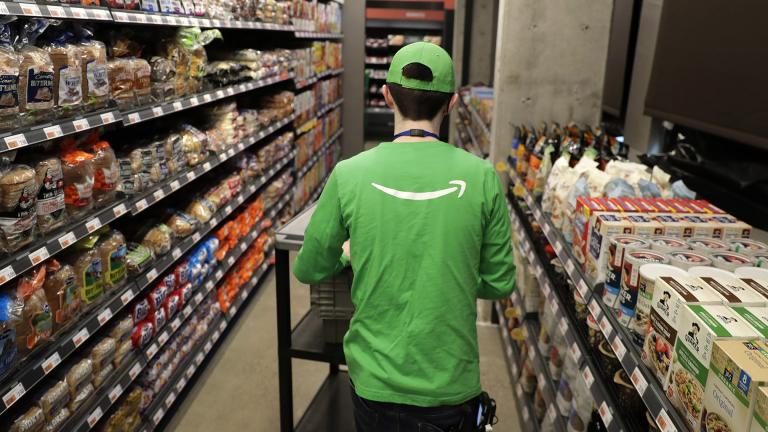 In this Feb. 21, 2020 photo, a worker pushes a cart inside an Amazon Go Grocery store set to open soon in Seattle’s Capitol Hill neighborhood. (AP Photo / Ted S. Warren)