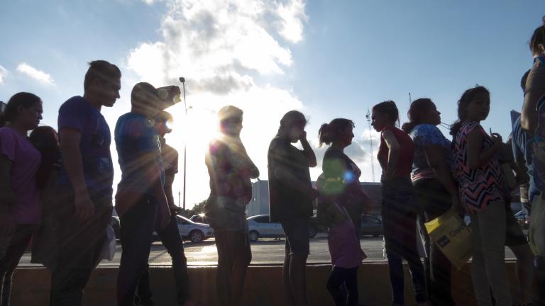 In this Oct. 5, 2019 file photo, migrants seeking asylum wait in line with their case paperwork during a weekly trip by volunteers, lawyers, paralegals and interpreters to the migrant campsite outside El Puente Nuevo in Matamoros, Mexico. (Denise Cathey / The Brownsville Herald via AP, File) In this Oct. 5, 2019 file photo, migrants seeking asylum wait in line with their case paperwork during a weekly trip by volunteers, lawyers, paralegals and interpreters to the migrant campsite outside El Puente Nuevo in Matamoros, Mexico. (Denise Cathey / The Brownsville Herald via AP, File)