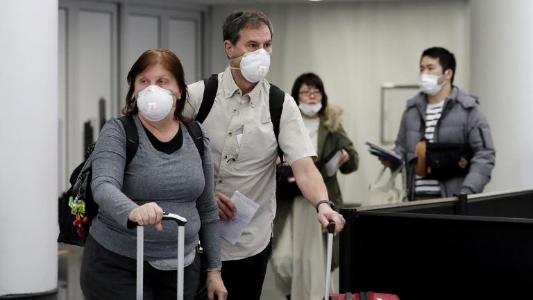 Travelers wear protective mask as they walk through in terminal 5 at O’Hare International Airport in Chicago, Sunday, March 1, 2020. (AP Photo / Nam Y. Huh) Travelers wear protective mask as they walk through in terminal 5 at O’Hare International Airport in Chicago, Sunday, March 1, 2020. (AP Photo / Nam Y. Huh)
