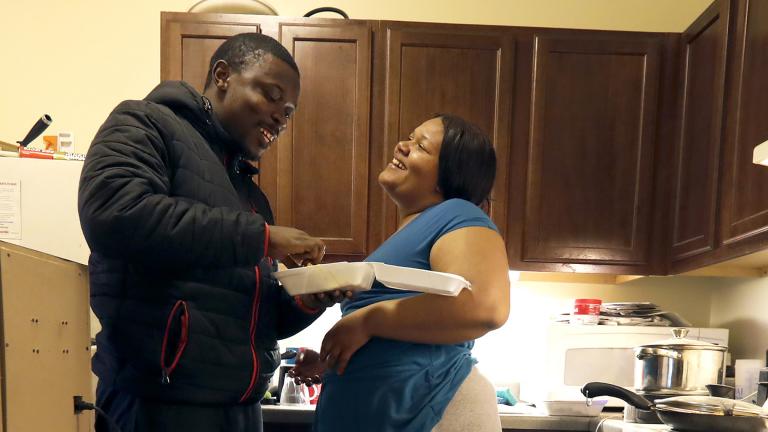 In this Thursday, Feb. 27, 2020, photo, Richard Butler and his fiance Amber laugh while they have breakfast in an apartment a friend is letting them live in on Chicago’s South Side. (AP Photo / Charles Rex Arbogast)