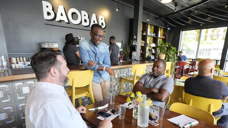 Hamissi Mamba talks to customers at his restaurant, Baobab Fare, Friday, May 24, 2024, in Detroit. (AP Photo/Carlos Osorio)