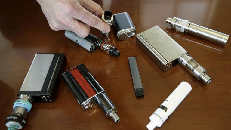 In this Tuesday, April 10, 2018 photo, a high school principal displays vaping devices that were confiscated from students at the school in Massachusetts. (AP Photo / Steven Senne)