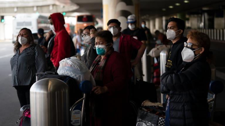 Travelers wait for a shuttle but to arrive at the Los Angeles International Airport in Los Angeles, Monday, Dec. 20, 2021. The Los Angeles County Department of Public Health reported more than 3,500 new cases of COVID-19 on Sunday as the number of daily new cases tripled over the week. (AP Photo / Jae C. Hong)