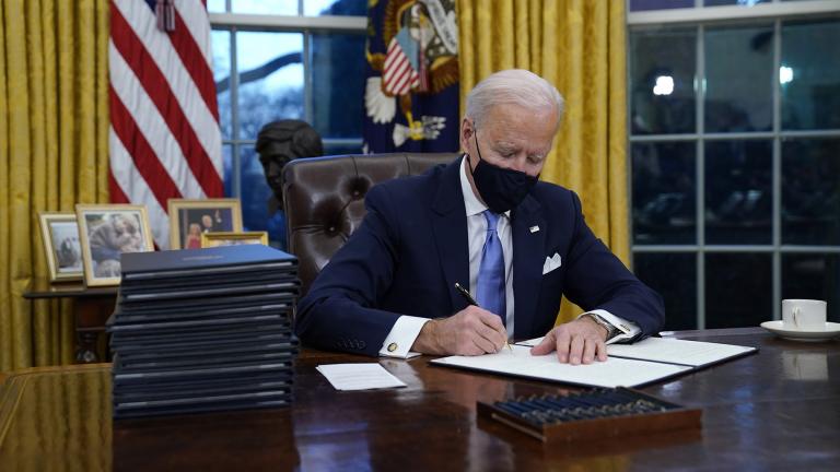 President Joe Biden signs his first executive order in the Oval Office of the White House on Wednesday, Jan. 20, 2021, in Washington. (AP Photo / Evan Vucci)