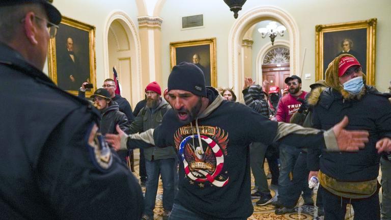 Protesters gesture to U.S. Capitol Police in the hallway outside of the Senate chamber at the Capitol in Washington, Wednesday, Jan. 6, 2021, near the Ohio Clock. (AP Photo / Manuel Balce Ceneta)