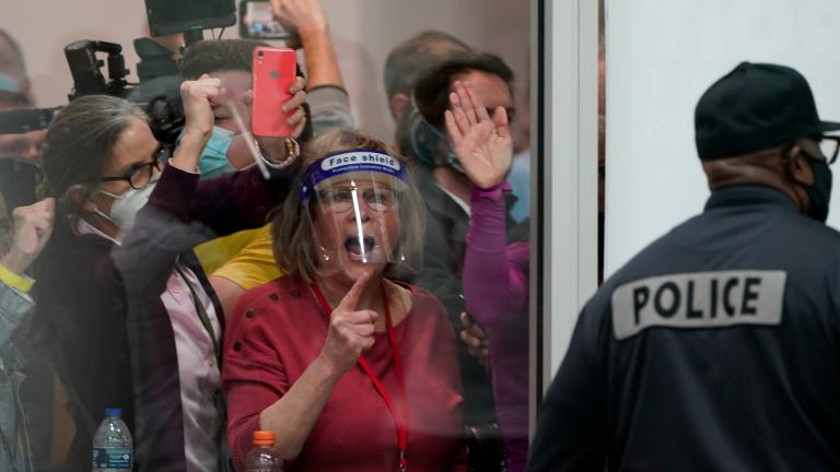 Election challengers yell as they look through the windows of the central counting board as police were helping to keep additional challengers from entering due to overcrowding, Wednesday, Nov. 4, 2020, in Detroit. (AP Photo / Carlos Osorio)