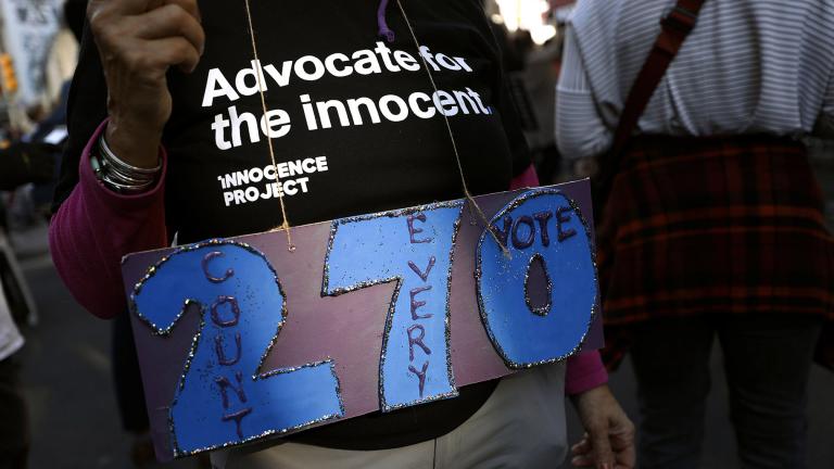 A person holds a sign referring to the number of electoral votes needed to win the presidency while demonstrating outside the Pennsylvania Convention Center where votes are being counted, Thursday, Nov. 5, 2020, in Philadelphia, following Tuesday’s election. (AP Photo / Rebecca Blackwell)