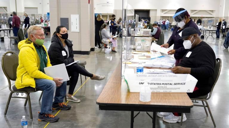 Election workers, right, verify ballots as recount observers, left, watch during a Milwaukee hand recount of presidential votes at the Wisconsin Center, Friday, Nov. 20, 2020, in Milwaukee. (AP Photo / Nam Y. Huh)