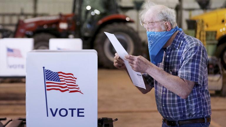 Robert Wilson reviews his selections on his ballot while voting at the town’s highway garage building Tuesday, April 7, 2020 in Dunn, Wis. (John Hart / Wisconsin State Journal via AP)