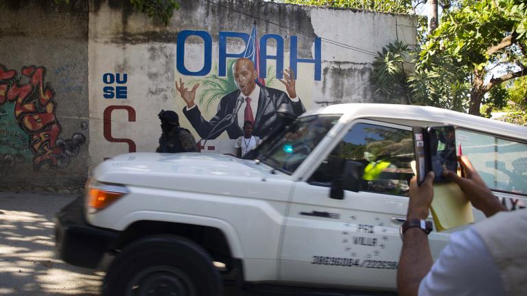 An ambulance carrying the body of Haiti’s President Jovenel Moise drives past a mural featuring him near the leader’s residence where he was killed by gunmen in the early morning in Port-au-Prince, Haiti, Wednesday, July 7, 2021. (AP Photo / Joseph Odelyn)