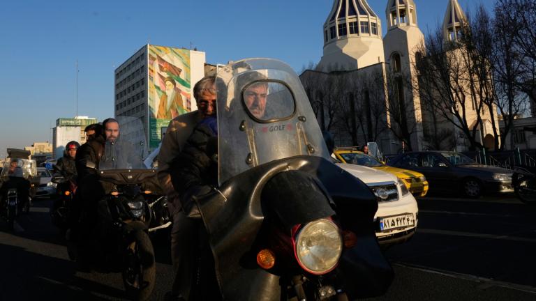 Commuters drive past Saint Sarkis church and a mural of the late Iranian revolutionary founder Ayatollah Khomeini in downtown Tehran, Iran, Wednesday, Feb. 25, 2026. (AP Photo / Vahid Salemi)
