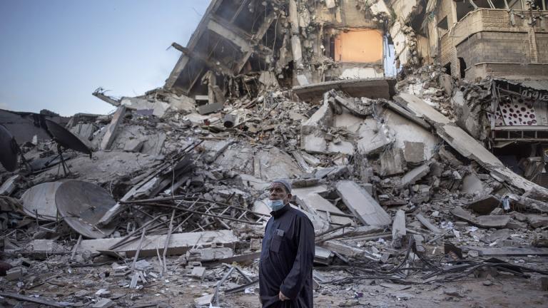 A Palestinian man looks at the destruction of a building hit by Israeli airstrikes in Gaza City, Thursday, May 13, 2021. (AP Photo / Khalil Hamra)