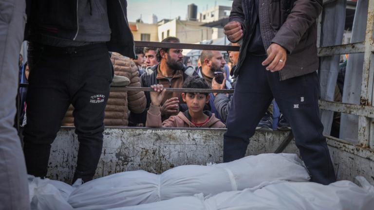 A boy looks at the bodies of Palestinians killed in the Israeli bombardment of the Gaza Strip as they are brought for burial at Al-Aqsa Hospital in Deir al-Balah, Wednesday, Jan. 15, 2025. (Abdel Kareem Hana / AP Photo)